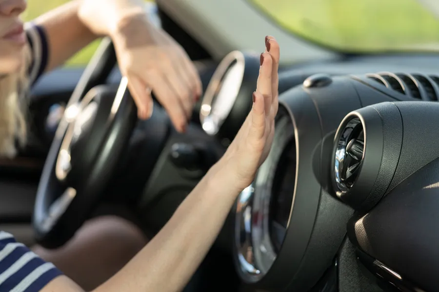 Hand am Lüftungsgitter im Fahrzeuginnenraum