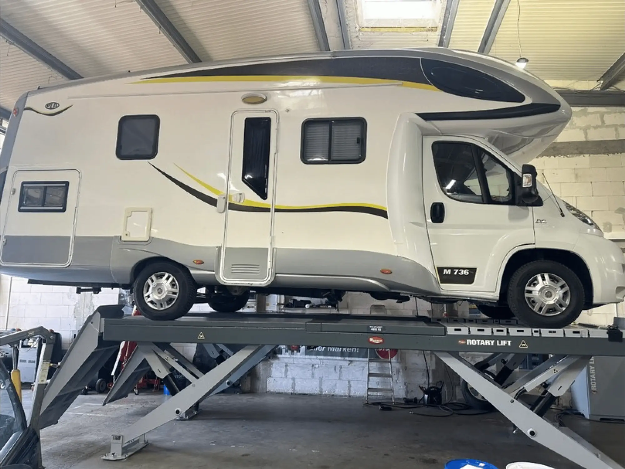 Weißes Wohnmobil in der Werkstatthalle